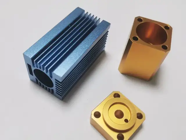 Anodised aluminium parts &mdash; blue heat sink and gold-anodised blocks